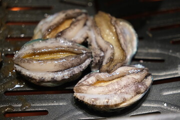 close up cooking abalone seafood on barbecue grill