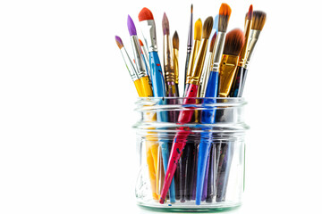 a jar filled with lots of different colored paint brushes