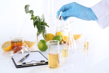 Aromatherapy product. Scientist developing essential oils at white table in laboratory, closeup