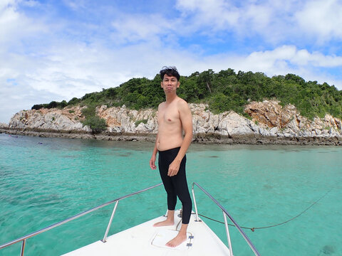 Man is on boat going to the beach.