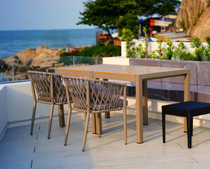 table and chair on rooftop of hotel on blur sea beach and hill view background