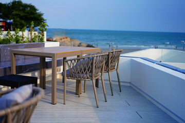 table and chair on rooftop of hotel on blur sea beach and hill view background