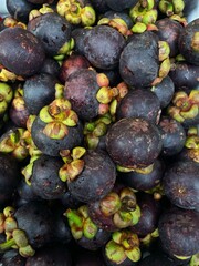 Closeup of Fresh ripe mangosteen fruits for sale in a supermarket. Mangosteen is a fruit with white flesh, sweet and delicious.