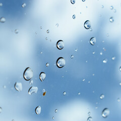 water drop on mirror with blue sky and white cloud background
