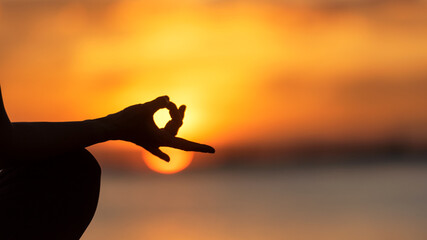 Close up hands Silhouette lifestyle woman yoga exercise for healthy life.  People pose balance body vital zen and meditation workout and fitness sport outdoor sunset near the beach