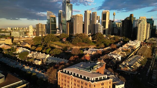Sydney, Australia: Aerial upward drone footage of Sydney business district skyline and historic buildings in the Rock area and Observatory Hill Park in Australia largest city in late afternoon