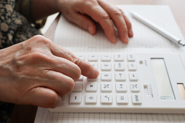 電卓で計算する高齢女性の手元