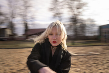 Portrait of a young beautiful blonde girl in a dark coat.