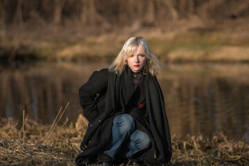Portrait of a young beautiful blonde girl in a dark coat.