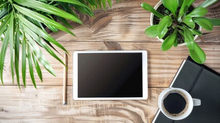 Blank screen tablet on wooden office desk with coffee pencil and plant