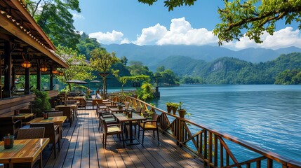 Naklejka premium A scenic lakeside restaurant with wooden deck overlooking a tranquil lake and mountains.