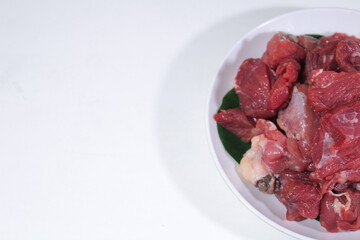 half a plate contains beef and lamb on a plain white background