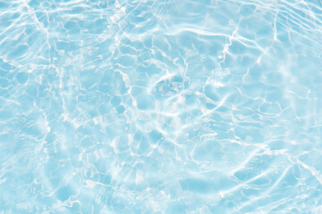 Blue water with ripples on the surface. Defocus blurred transparent blue colored clear calm water surface texture with splashes and bubbles. Water waves with shining pattern texture background.