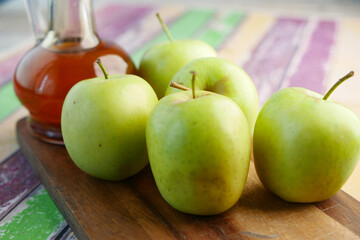 apple vinegar in glass bottle with fresh green apple on table 