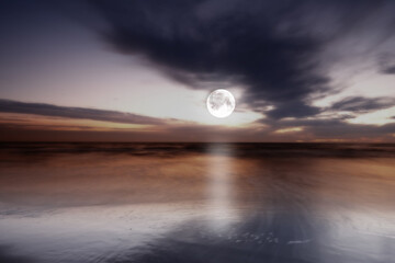 Fototapeta premium Ocean, sky and moon at night for landscape with mystical cloud, natural astronomy or cosmos glow of water reflection. Nature, lunar and moonlight on beach for travel, illumination or celestial beauty