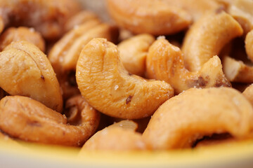 cashew nuts in a small bowl on black color background 