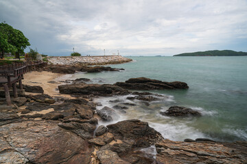 A wooden bridge along the coast with a pier extending into the sea