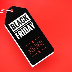 A black sale tag on a red background with the words Black Friday big deal, signaling special discounts, deals, prices or promotions