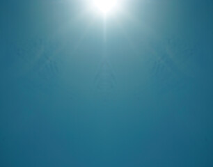 blue sky without clouds and sun reflection.The sun shines bright in the daytime in summer. Sun shining over a heavenly blue clear sky background. sunrays beams.