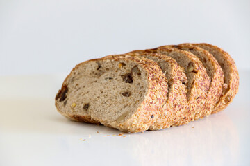 Healthy whole grain brown bread with raisins and walnuts, 5 slices against white background, healthy eating and lifestyle, balanced diet concept