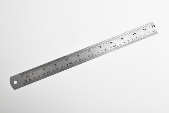 Iron ruler on a white background. Stainless steel ruler. Stationery and work tools made of metal steel, isolated on white background