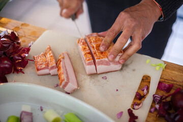まな板でベーコンを切る