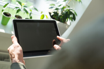 hands of a man holding blank tablet device.