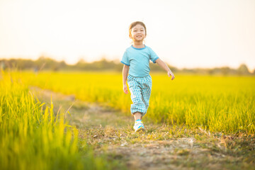 baby girl with happy time on freedom in emotional in outdoor by run play on grasses floor in rice fields blue dress