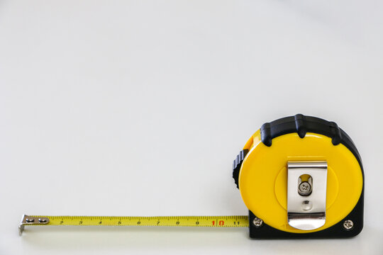 Black and yellow tape measure locked at 10cm at the bottom length of white background, accuracy and precision concept, copy space above