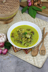 Gulai kambing or Indonesian traditional lamb curry, popular Indonesian food special in hari raya made from lamb meat, spices, and coconut milk. grey rustic background.