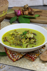 Gulai kambing or Indonesian traditional lamb curry, popular Indonesian food special in hari raya made from lamb meat, spices, and coconut milk. grey rustic background.