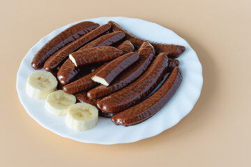 Chocolate covered banana flavored slices on a white plate from above