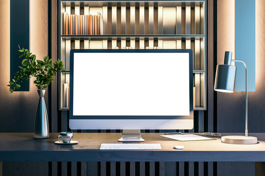 A modern computer display with a blank white screen on a wooden desk, with books, a plant, and ambient lighting, showing a concept of a workplace. 3D Rendering