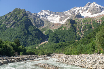 The bubbling glacial-clear water of a mountain river with large stones high in the mountains. Environmentally friendly water flows down from a glacier in the mountains. Nature in the mountains.