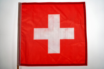 Close-up top view of red and white Flag of Switzerland against white background. Photo taken June 22nd, 2024, Zurich, Switzerland.