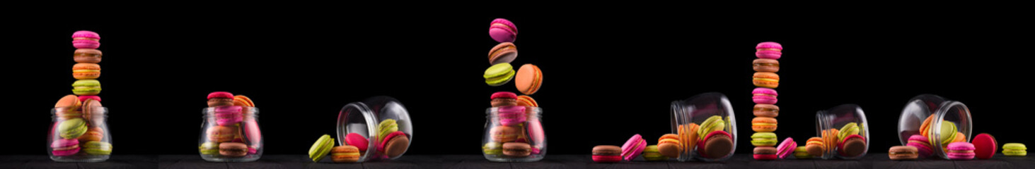 Jar of french colorful macaroon or macaron on wooden table isolated on black