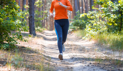 women athlete running through the woods.