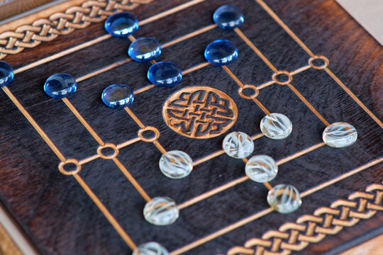 Nine Men's Morris requires strategic placement and movement of pieces to create mills-three in a row. When a mill is formed, a player removes an opponent's piece