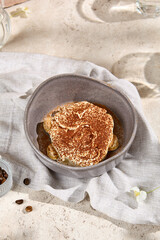 Portion of Tiramisu Dessert in Sunlit Summer Setting with Shadows