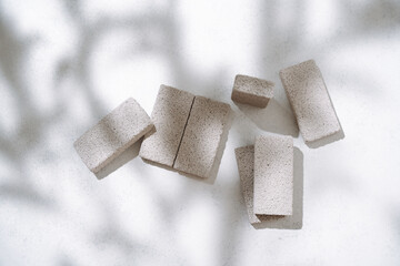 Cosmetic products presentation flat lay mockup scene made with  porous stone pedestals under the leaves shadow. Elegant mediterranean style stage for your design.