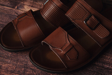 Men's leather slippers on a wooden surface. Men's shoes