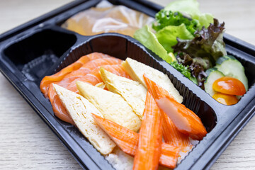 Japan raw salmon sashimi, sweet egg and imitation crab stick on rice in Japanese food restaurant. Japanese traditional food or with low calories