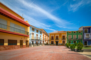 View of the Plaza Mayor in Pliego, Region of Murcia, Spain, with its typical colorful building facades and midday light