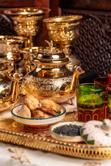 Ornate Golden Moroccan Teapots and Glasses With Dates on a Tray