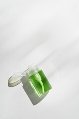 Pump dispenser with green liquid for skin care, beauty routine, skin health. Cosmetic product face lotion, facial cleanser, micellar water mockup, natural organic cosmetics, minimal style photo