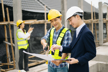 Architect Asian team working with colleagues in the construction site. Architecture engineering on big project.
