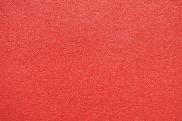 Close-up view of bright red textured paper, perfect for backgrounds or graphic design projects.