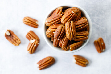 Pecan nuts in a white bowl.