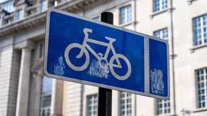 Obraz premium Blue bicycle route sign on a high street