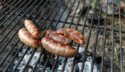 Sausages grilling on an outdoor firepit